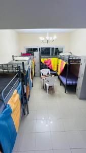 Dubai Star Hostel في دبي: غرفة مع العديد من الأسرة بطابقين وطاولة