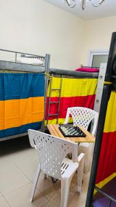 a table and a chair in a room with a bed at Dubai Star Hostel in Dubai