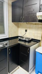 a kitchen with a stove and a counter top at Dubai Star Hostel in Dubai