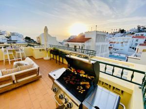 uma varanda com um grelhador no topo de um edifício em Oceanview Carvoeiro Terrace Apartment em Carvoeiro