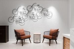 two chairs and a wall with bicycles on it at Bi Eco Suites Hanoi in Hanoi