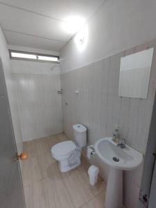 a white bathroom with a toilet and a sink at Cabaña Isabella in San Bernardo del Viento