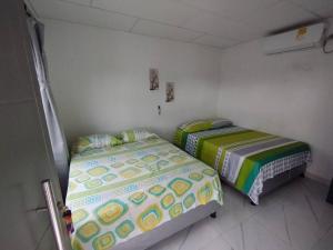 twee bedden in een kleine kamer met bij Cabaña Isabella in San Bernardo del Viento