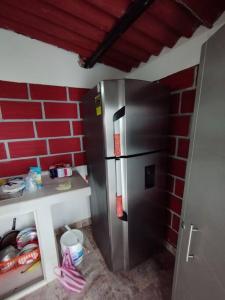 a stainless steel refrigerator in a kitchen with a brick wall at Cabaña Isabella in San Bernardo del Viento