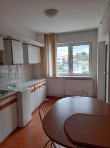 een keuken met een tafel en een tafel en stoelen bij Spacious 4 rooms downtown apartment in Pitesti in Piteşti