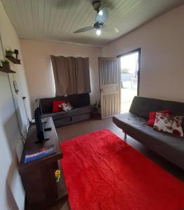 a living room with a couch and a red rug at Casa do Porto - a 600m do Mar e da Lagoa in Florianópolis
