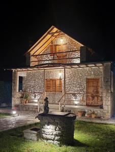 une maison en pierre avec des lumières devant elle dans l'établissement The Village House, à Korçë