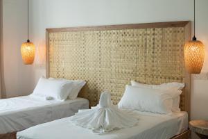 two beds with white sheets and pillows in a room at Manta Reserve in Maalhos +55 photos