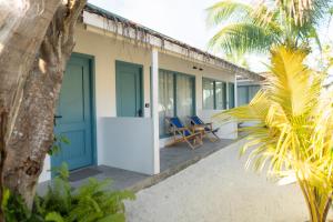 a house on the beach with blue doors and chairs at Manta Reserve in Maalhos
