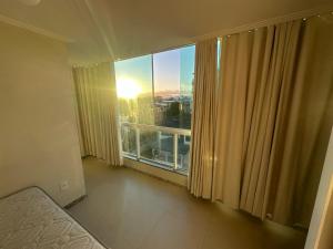 a room with a large window with a view at Apartamento Iriri Vista para o Mar in Iriri