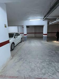 a white car parked in an empty parking garage at Appart calme & chaleureux en résidence près de la mer in Monastir