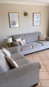 a living room with a gray couch and a table at Toscana Village Resort in Airlie Beach