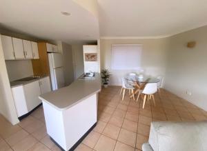 a kitchen and dining room with a table and chairs at Toscana Village Resort in Airlie Beach