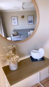 a living room with a mirror and a table with flowers at Toscana Village Resort in Airlie Beach