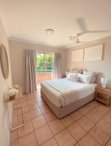 a bedroom with a bed and a large window at Toscana Village Resort in Airlie Beach