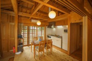 uma cozinha com mesa e cadeiras num quarto em かたあきの里 em Ilhas Miyako