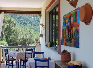 a dining room with a table and chairs and a large window at Hotel Su Lithu in Bitti