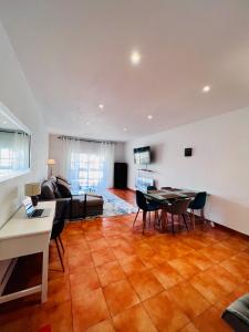 uma sala de estar com um sofá, uma mesa e cadeiras em Oceanview Carvoeiro Terrace Apartment em Carvoeiro