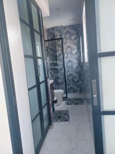 a bathroom with a toilet and a glass door at Rowena's River Resort in Nalsian