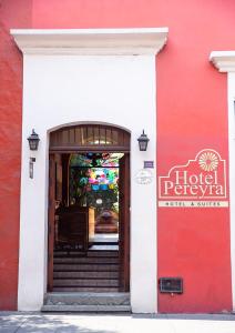 瓦哈卡德華雷斯的住宿－Hotel Casa Pereyra，一座红色和白色的建筑,设有开放式门