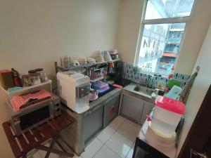 a kitchen with a coffee maker and a sink at Kuree Hut in Semporna