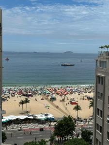 una playa con muchas sombrillas y gente en ella en Belíssimo apartamento com vista para a praia de Copacabana e cristo, en Río de Janeiro