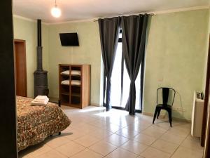 錫納倫加的住宿－Appartamento Turistico FRAU A，卧室配有床、椅子和窗户。