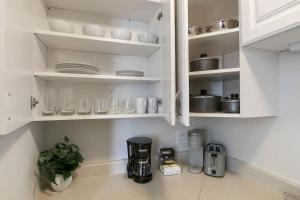 uma cozinha com armários brancos e comodidades para preparar café em Sleek Gold Coast Studio Apartment - Chestnut 19E em Chicago