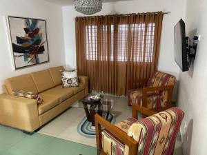 ein Wohnzimmer mit einem Sofa, einem Tisch und Stühlen in der Unterkunft My Beautiful Place in Santiago de los Caballeros