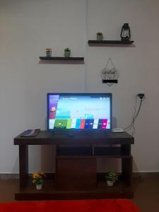 a flat screen tv sitting on a wooden table at Casa do Porto - a 600m do Mar e da Lagoa in Florianópolis