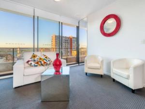 a living room with a couch and two chairs and a table at 806/67 Arvia in Newcastle