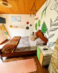 a bedroom with a bed with a tiger print on the wall at hospedagem bicho do mato arts in Brotas