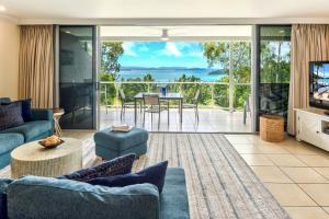 a living room with a couch and a tv at Blue Water Views Apartments in Hamilton Island