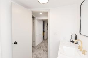 a bathroom with white walls and a sink and a mirror at NEW Remodeled Townhome Close to Downtown in Fargo +19 photos