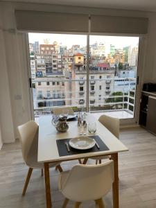 布宜諾斯艾利斯的住宿－MAO Buenos Aires - Apt. en Recoleta，餐桌、椅子和大窗户