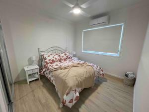 sypialnia z łóżkiem i białą ścianą w obiekcie Hunter Valley D'Vine Stay II w mieście Nulkaba