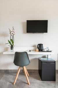 escritorio con silla negra y TV en la pared en Villa Licari Stagnone en Marsala