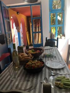 una mesa con un tazón de comida y una botella de vino en Dar el pirata, en Asilah