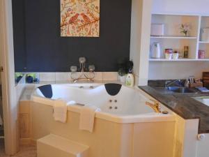 a large bath tub in a bathroom with a sink at Romance Chalet on Gallery Walk with Spa, Fireplace, WiFi & Netflix in Mount Tamborine