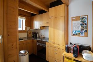 Una cocina con gabinetes de madera y un horno de estufa. en Artus 6, en Bettmeralp