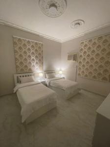 a bedroom with two beds and two lights on the ceilings at فيلا ميسرة الهدا in Al Hada