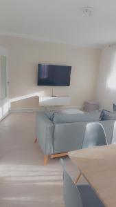 sala de estar con sofá y TV de pantalla plana en Appartement logement entiers en Rodez
