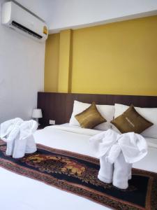 una camera da letto con un letto con stivali bianchi di MM Hill Koh Samui Hotel - SHA Certified a Chaweng Beach