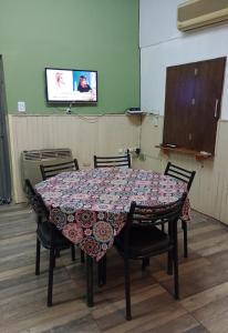 a table with chairs and a tv in a room at Alojamiento mendoza in Las Heras