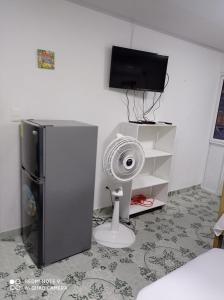 a room with a refrigerator and a fan and a tv at Apartamentos AJ place 2 in San Andrés