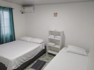 Habitación pequeña con 2 camas y estante en Apartamentos AJ place 2 en San Andrés