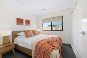 a white bedroom with a bed and a window at Winter Valley Retreat - Palatial Pad in the Valley! in Alfredton