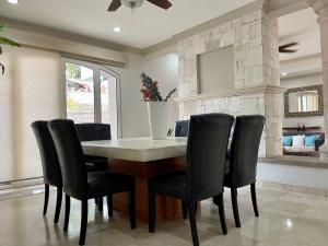 a dining room with a table and black chairs at Guerrero 318 in Puerto Vallarta