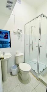 a bathroom with a toilet and a glass shower at Nomada 870 - Hotel Work in Osorno
