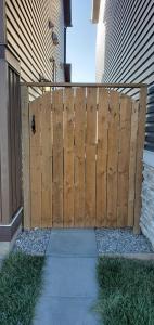 uma cerca de madeira em frente a uma casa em Delightful 1-bedroom Private Suite in a New Home em Calgary